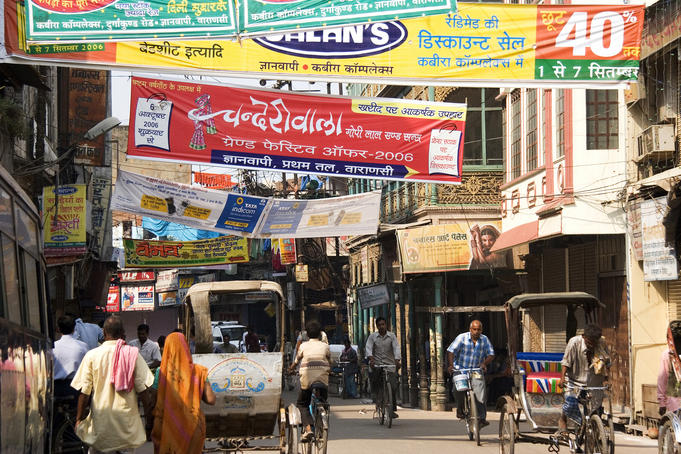 Cycle rickshaws and people on the busy streets of town.