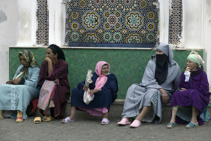 Women sit on the side of the street, Moulay Idriss