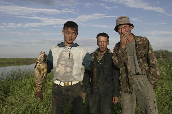 Portrait of Kazak men with fish.