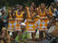 Women dancing and men drumming during a celebration.