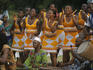 Women dancing and men drumming during a celebration.