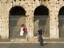 Tourist photographing man in gladiator costume at Colosseum.