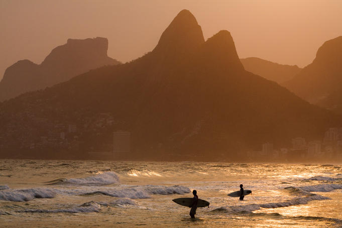 Surfers at sunset on Ipanema Beach, with the twin peaks of Morro Dois Irmaos (Two brothers mountain) in backgound.