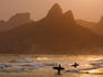 Surfers at sunset on Ipanema Beach, with the twin peaks of Morro Dois Irmaos (Two brothers mountain) in backgound.