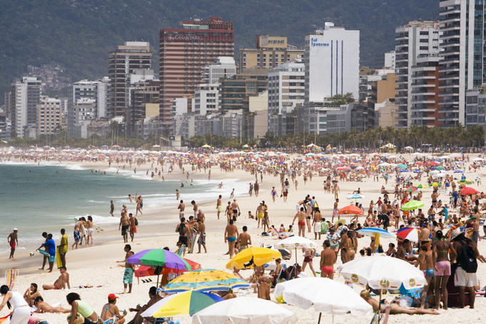 People enjoying the beach and surf at Ipanema Beach.