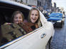 Girls hanging out of limousine window on Royal Mile.