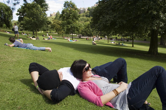 People enjoying sunshine in Princes Street Gardens.