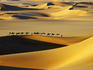 Tuareg nomads with camels in sand dunes of Sahara Desert, Arakou.