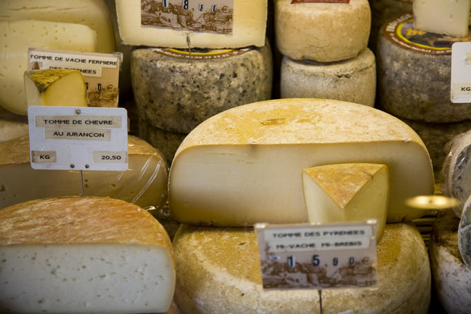 Variety of cheeses for sale at a Saturday market.