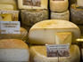Variety of cheeses for sale at a Saturday market.