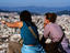 Two women enjoying ice cream and views over city from Castell de Montjuic.
