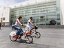 Women riding city council bikes through town, Barcelona