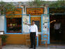 Waiter standing in front of tavern.