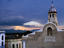 Iglesia Parroquial Mayor de San Salvador church, and surrounding Sierra Maestra mountains under stormy sky.