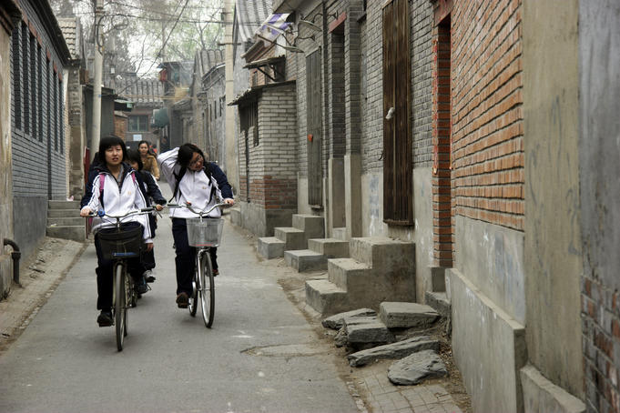 Cycling through a narrow Beijing hutong laneway.