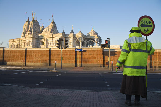 Lollipop lady in front of Shri Swaminarayan Mandiir Hindu Temple, Neasdon.