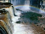 Rainbow spanning part of Iguazu Falls, seen from Brazilian shore.