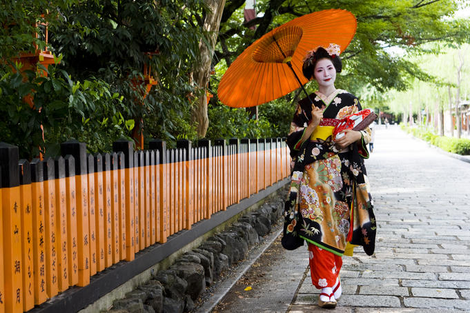 Young maiko (apprentice geisha) girl, walking with umbrella, in Shirakawa-miname-dori street.