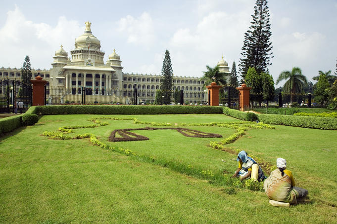 Workers on lawn outside the Vidhana Soudha, which houses the state legislature.