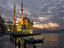 Ortakoy Mosque looking towards the Bosphorus Bridge, under a cloudy sky.