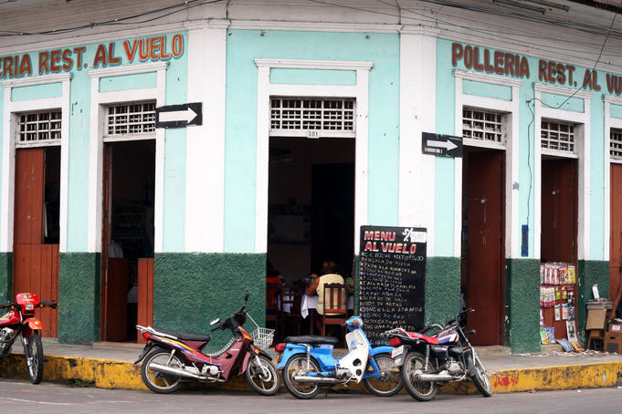 Motorbikes and scooters parked outside restaurant on Avenida Condamine, in the city centre.