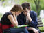 Young couple studying map on park bench in Kronvalda Park.