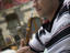 Man smoking sheesha water pipe, Jabri House courtyard restaurant.