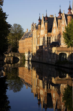 Canal with reflection of buildings and bridge.