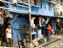 Couple hanging up laundry in front of their house in Malate district slum.