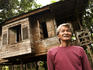 Man outside his rural wooden house.