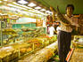 Man holding lobster at waterfront seafood restaurant.