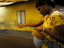 Woman stringing out coconut shell fibre for eventual use in weaving door matts.
