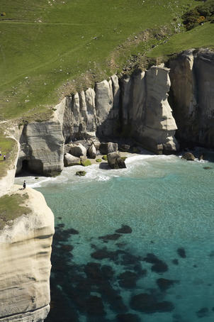Aerial of tourists and cliffs at Tunnel Beach.