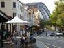 Outdoor dining at The Rocks Cafe, 99 George Street, The Rocks, with Sydney Harbour Bridge in background.