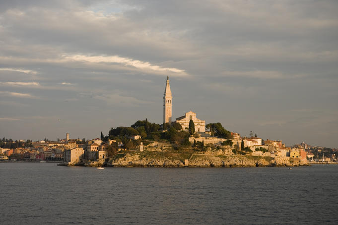 Rovinj town with Cathedral of St Euphemia on hilltop at sunset.