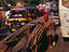 Man transporting bamboo poles on bicycle cart through town.