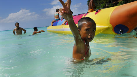 Boy giving the v sign while playing in Boracay's waters.