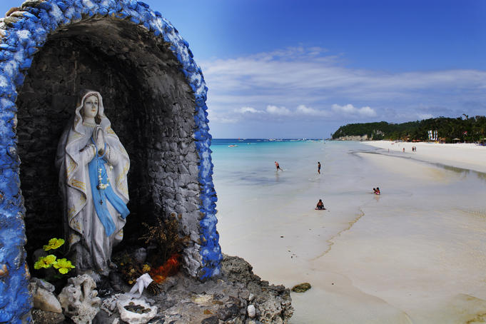 Icon in an enclosed stone shrine looking out over White Beach.