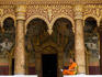 Monk studying on wall of Wat Sensoukharam.
