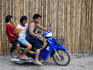 Three people and drinks on motor scooter.