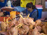 Poultry cleaners preparing meat at main market.