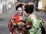Geisha checking photos on digital camera.