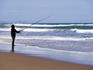 Surf fisherman casting from beach.