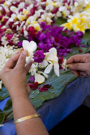 Making flower leis on a string.