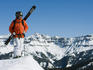 Skier standing on ridge overlooking the mountains around Telluride ski system.