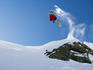Skier doing a front flip over a cliff, at Taos Ski Resort.