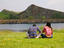 Couple sitting by a lake.