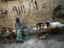 Man smoking a shisha pipe near Darb al-Ahmar street in the old city, while a sheep looks on.