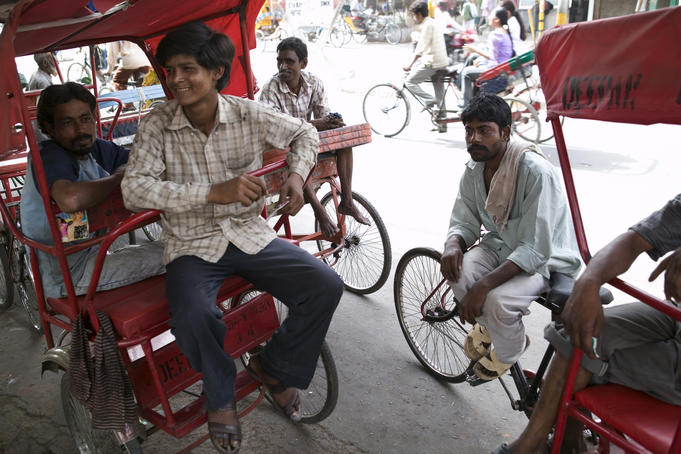 Rickshaw pullers having a laugh together while on a break.