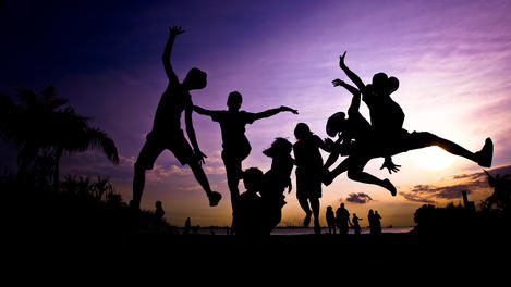 Kids jumping in sunset silhouette, Sentosa.